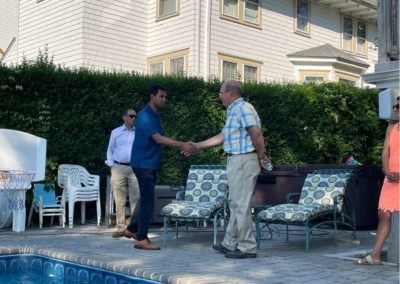 Vin Gopal shaking a man's hand at a pool.