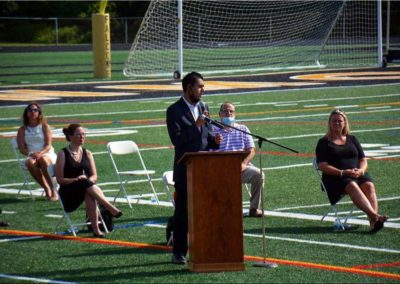 Vin Gopal giving a speech on a sports field.