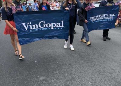 Vin Gopal supporters holding a banner with his logo in a parade.