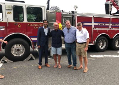 Vin Gopal with a group of men in front of a firetruck.